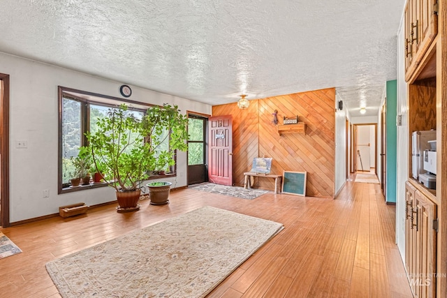 4 N 100 W, Fairfield, ID 83327 - foyer entrance with healthy amount of natural light, wood walls, light wood-style floors, and a textured ceiling