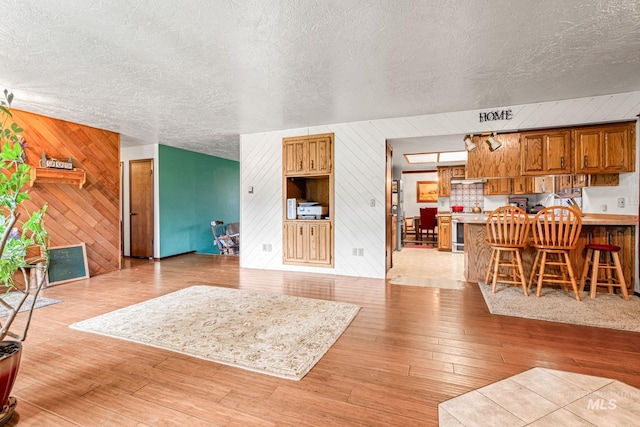 4 N 100 W, Fairfield, ID 83327 - living area with wood walls, light wood-type flooring, and a textured ceiling