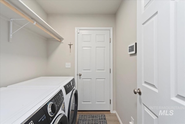 laundry room with washer and dryer and dark hardwood / wood-style floors