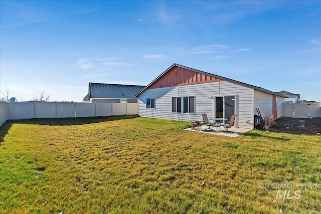 rear view of property featuring a lawn and a patio