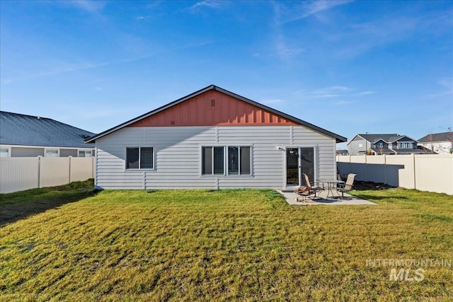 rear view of property with a yard and a patio area