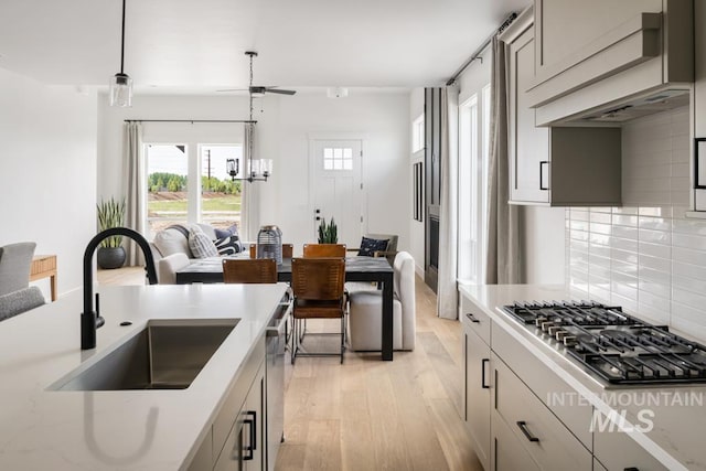 2005 W Freya Ct, Eagle, ID 83616 - kitchen featuring a sink, appliances with stainless steel finishes, light wood finished floors, backsplash, and ceiling fan