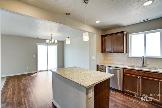 kitchen featuring dishwasher, a kitchen island, pendant lighting, and dark hardwood / wood-style floors