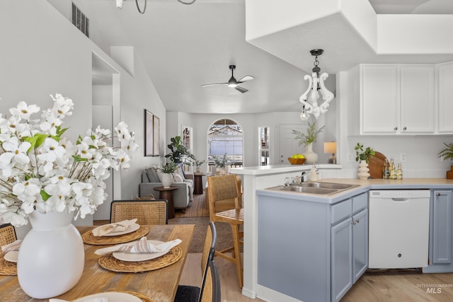 kitchen featuring sink, white cabinetry, decorative light fixtures, dishwasher, and kitchen peninsula