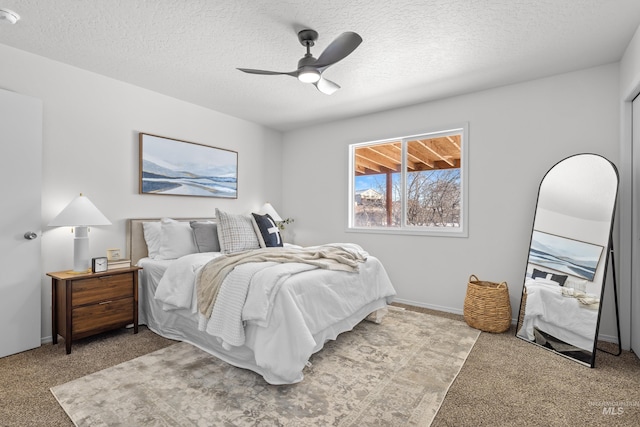 bedroom featuring light carpet, a textured ceiling, and ceiling fan