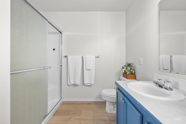 bathroom with vanity, wood-type flooring, a shower with door, and toilet