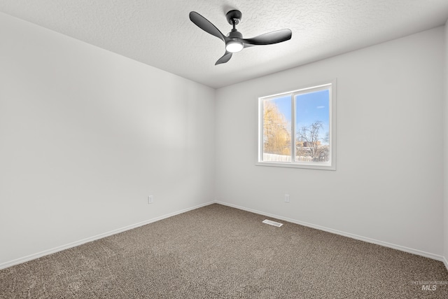 carpeted empty room featuring ceiling fan and a textured ceiling