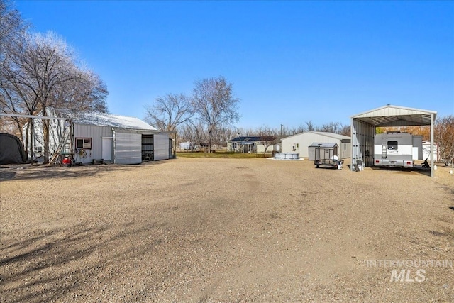 view of yard featuring a pole building, a detached garage, and an outdoor structure