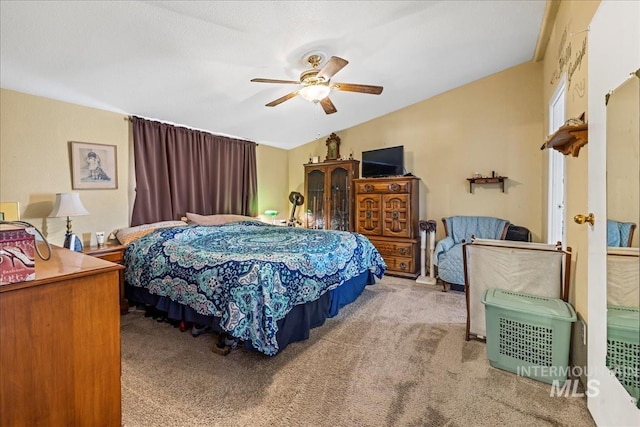 carpeted bedroom featuring ceiling fan and vaulted ceiling