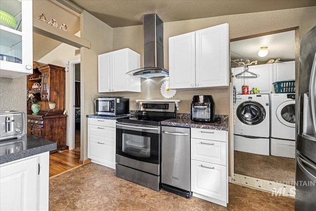 kitchen featuring wall chimney exhaust hood, washer and clothes dryer, white cabinets, and stainless steel appliances