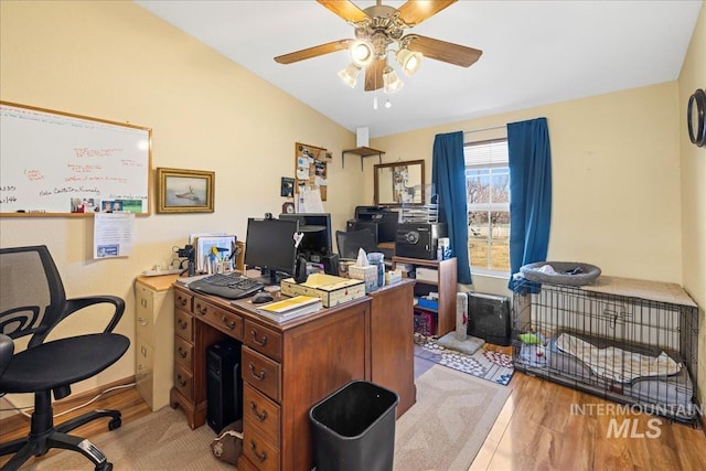 home office with ceiling fan, vaulted ceiling, and light wood-style floors