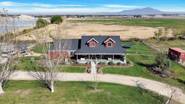 3976 Ranch Ln, Emmett, ID 83617 - view of front of house with dirt driveway, fence, covered porch, a water and mountain view, and a front yard