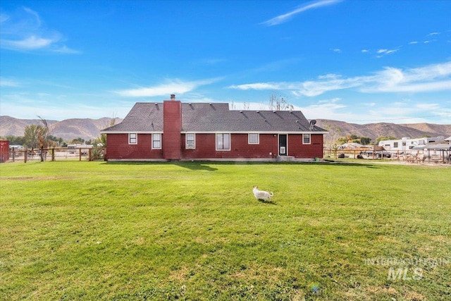 3976 Ranch Ln, Emmett, ID 83617 - back of property with a chimney, a mountain view, fence, and a yard