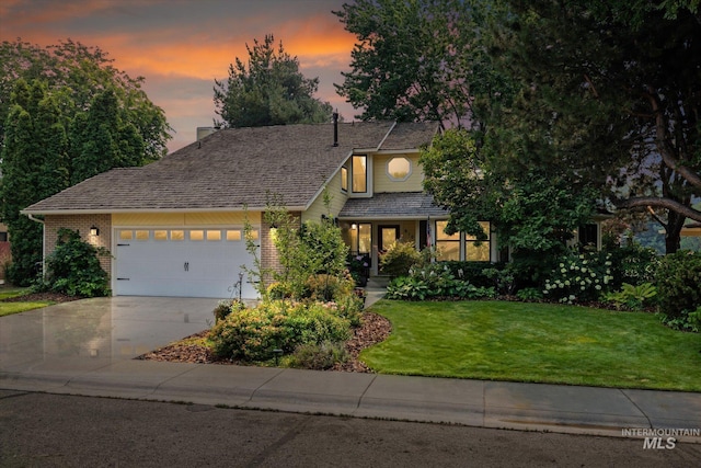 view of front of house with a garage and a yard