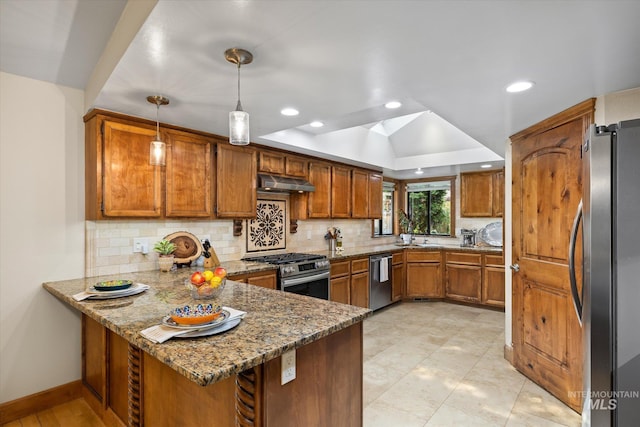 kitchen featuring tasteful backsplash, kitchen peninsula, stone counters, pendant lighting, and stainless steel appliances