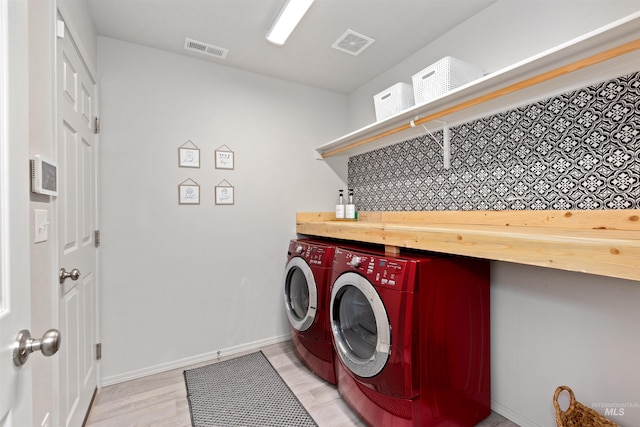 8408 E Dutchman St, Nampa, ID 83687 - clothes washing area featuring washing machine and clothes dryer, laundry area, light wood-style flooring, baseboards, and visible vents