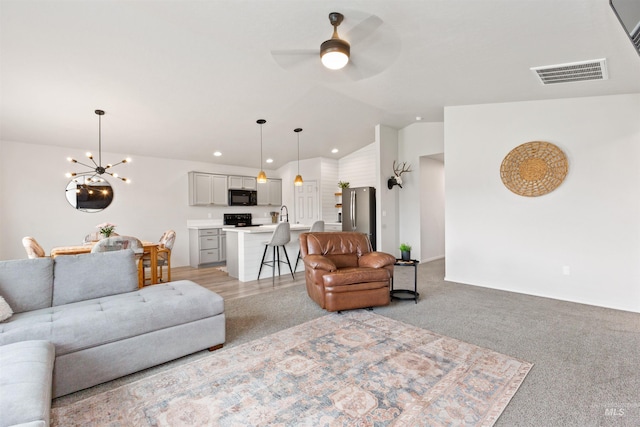 8408 E Dutchman St, Nampa, ID 83687 - living room with light carpet, ceiling fan with notable chandelier, recessed lighting, vaulted ceiling, and visible vents