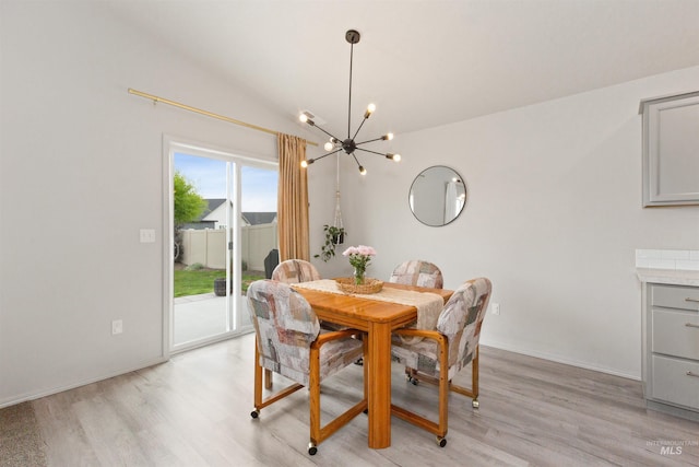 8408 E Dutchman St, Nampa, ID 83687 - dining room featuring baseboards, a notable chandelier, vaulted ceiling, and light wood-style floors