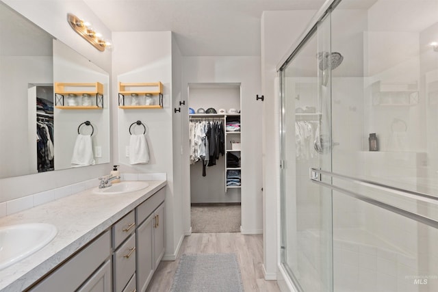 8408 E Dutchman St, Nampa, ID 83687 - bathroom featuring double vanity, a sink, wood finished floors, and a stall shower