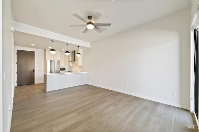unfurnished living room with baseboards, a ceiling fan, and light wood-style flooring