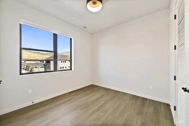 unfurnished bedroom with baseboards, visible vents, and wood finished floors