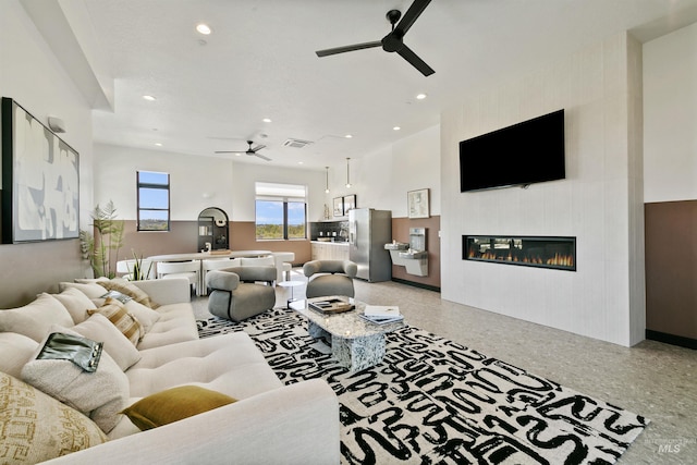 living area featuring visible vents, light speckled floor, ceiling fan, recessed lighting, and a tiled fireplace