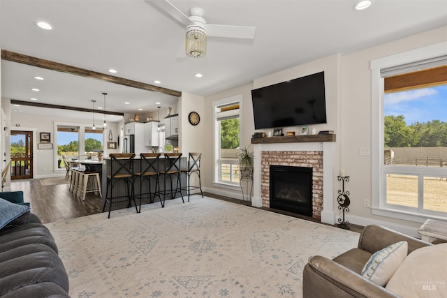894 Main St, Star, ID 83669 - living area featuring light wood-style floors, a ceiling fan, recessed lighting, a brick fireplace, and beamed ceiling