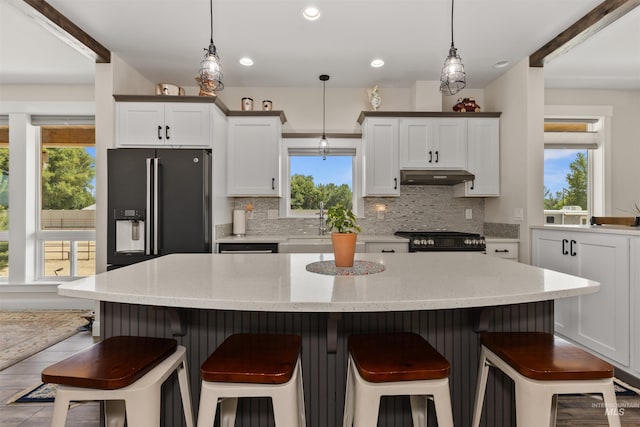 894 Main St, Star, ID 83669 - kitchen with black gas range, under cabinet range hood, tasteful backsplash, hanging light fixtures, and recessed lighting