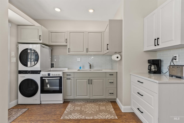 894 Main St, Star, ID 83669 - kitchen featuring electric stove, stacked washer / dryer, decorative backsplash, dark wood finished floors, and light countertops
