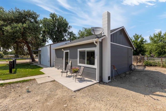 894 Main St, Star, ID 83669 - back of property with a patio, board and batten siding, and a chimney