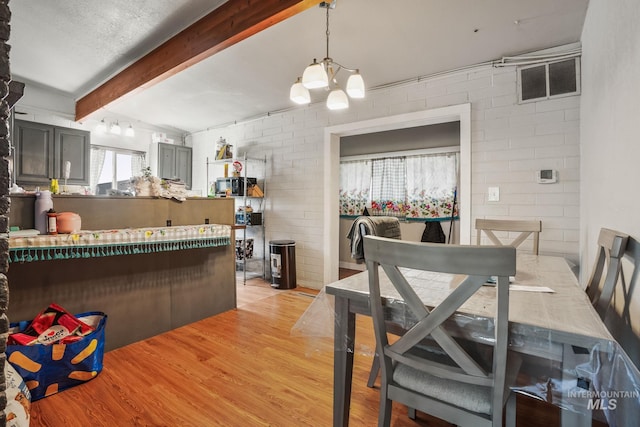 909 Victoria Ave, Fruitland, ID 83619 - dining room featuring light wood-style floors, beam ceiling, and a chandelier