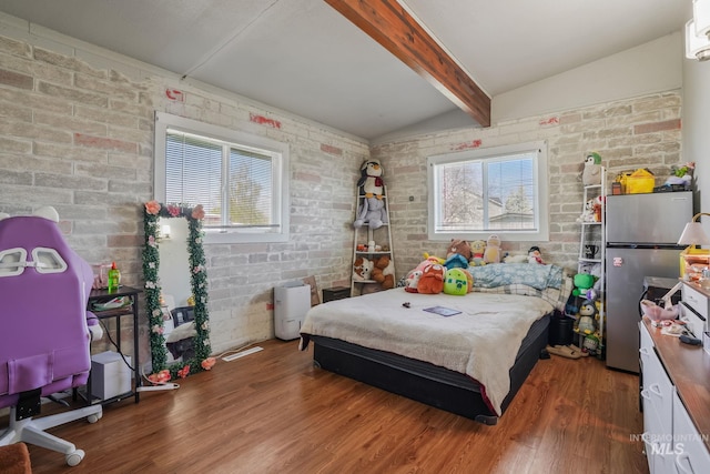 909 Victoria Ave, Fruitland, ID 83619 - bedroom with brick wall, wood finished floors, and freestanding refrigerator