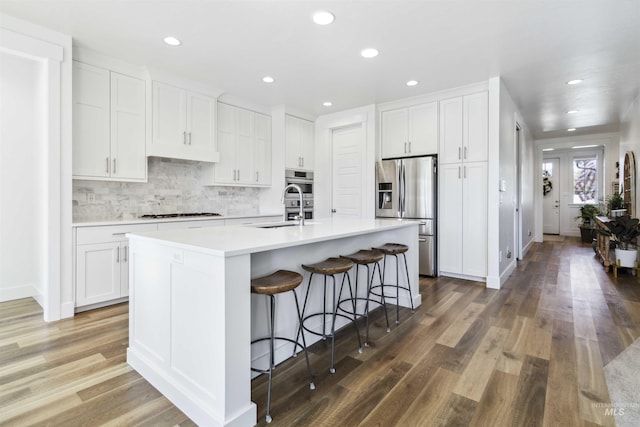 5916 S Wayland Way, Meridian, ID 83642 - kitchen with stainless steel refrigerator with ice dispenser, a sink, a breakfast bar area, white cabinets, and recessed lighting