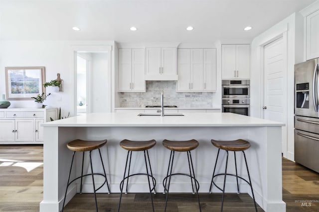 5916 S Wayland Way, Meridian, ID 83642 - kitchen with stainless steel appliances, a sink, white cabinets, wood finished floors, and recessed lighting