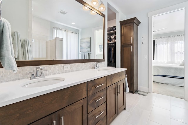 5916 S Wayland Way, Meridian, ID 83642 - ensuite bathroom with double vanity, tile patterned flooring, decorative backsplash, and a spacious closet