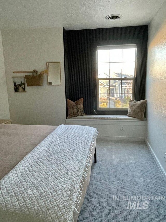 bedroom featuring a textured ceiling and carpet