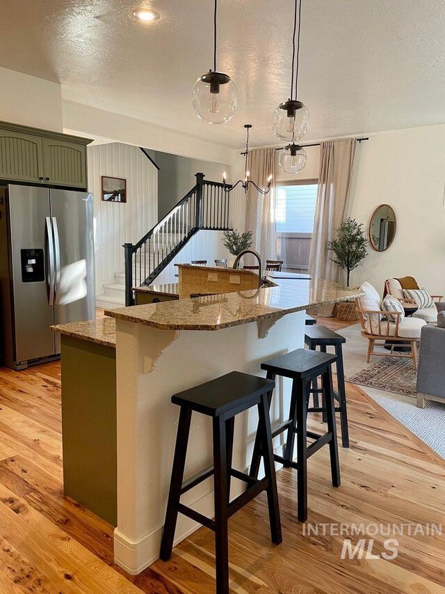 sitting room featuring light wood-type flooring and an inviting chandelier