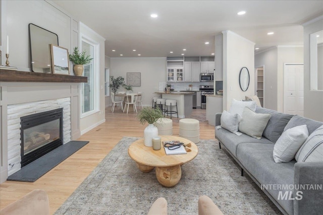 4975 N Morninggale Way, Boise, ID 83713 - living room with light wood finished floors, recessed lighting, ornamental molding, and a glass covered fireplace