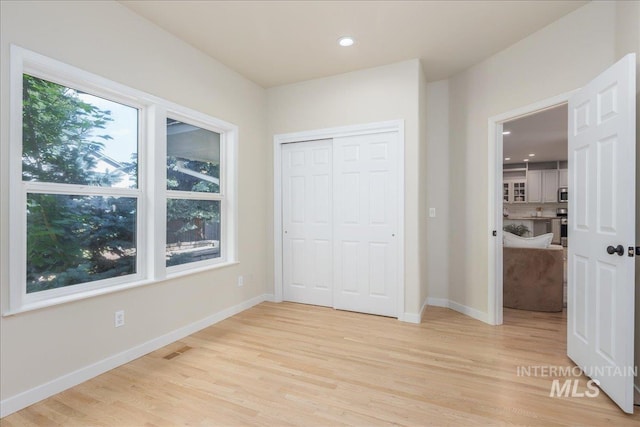 4975 N Morninggale Way, Boise, ID 83713 - unfurnished bedroom with multiple windows, light wood-style floors, recessed lighting, and a closet