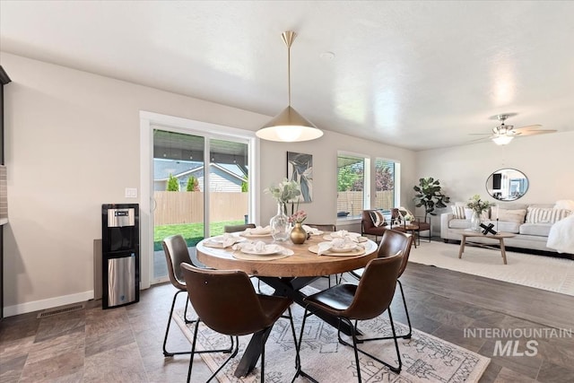dining room with a ceiling fan and baseboards