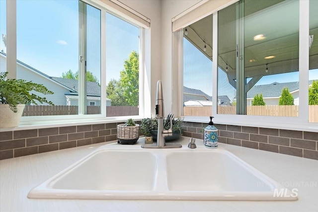 kitchen view of a sink and light countertops