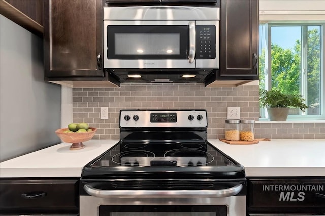 kitchen with appliances with stainless steel finishes, light countertops, dark brown cabinets, and tasteful backsplash