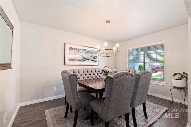 dining space featuring a chandelier, dark wood-style flooring, and baseboards