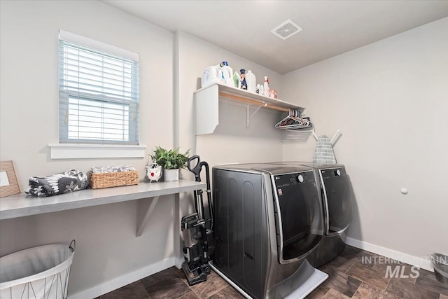 laundry area with independent washer and dryer and baseboards