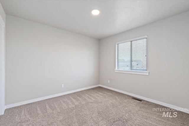 empty room featuring carpet floors and baseboards