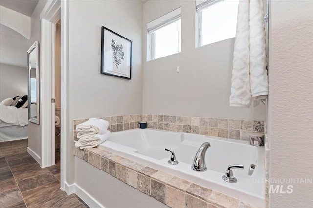 full bath featuring toilet and a garden tub