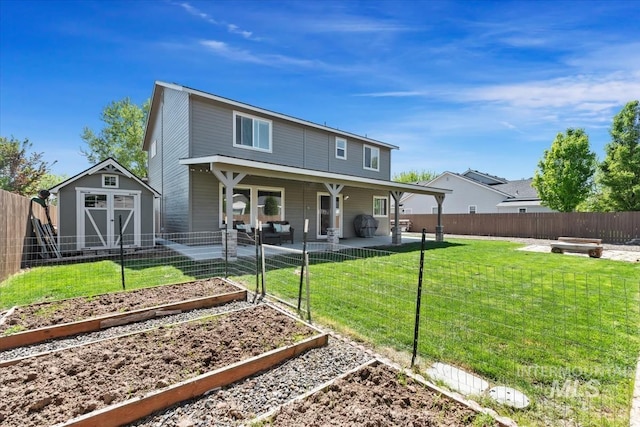 rear view of property featuring a garden, a shed, and an outbuilding