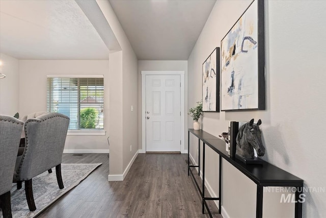 foyer entrance with dark wood finished floors and baseboards
