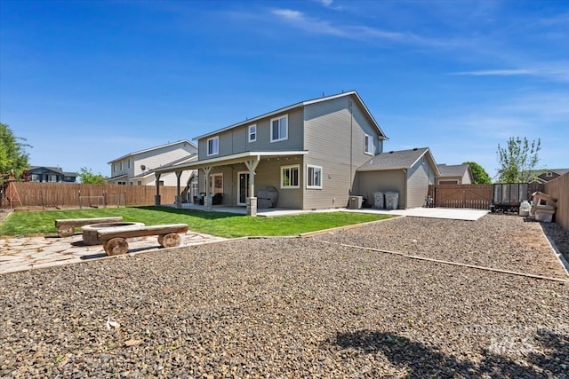 back of property with a patio, a fenced backyard, and a gate