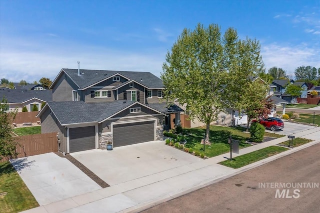 craftsman house with an attached garage, fence, driveway, stone siding, and a residential view